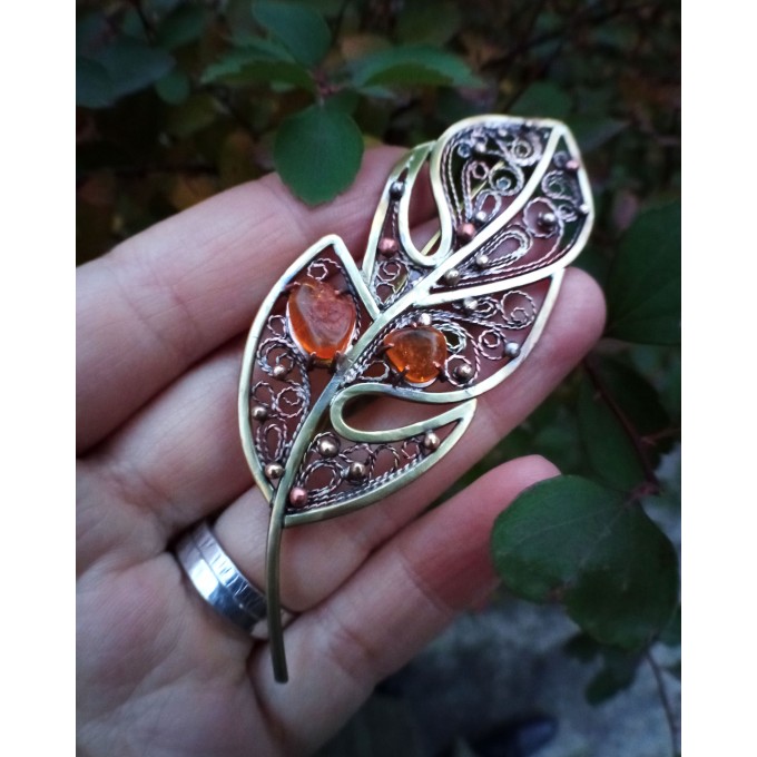 Brass feather brooch with amber