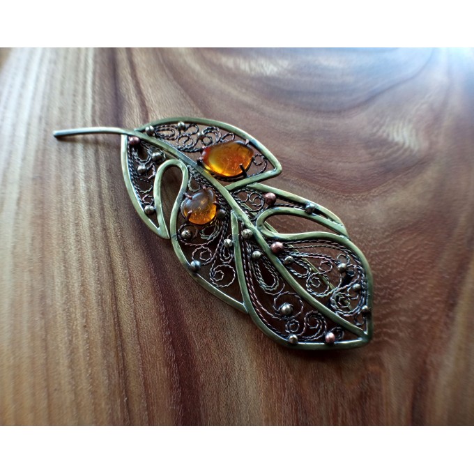 Brass feather brooch with amber